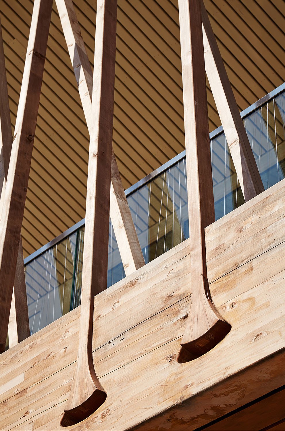 The wood battens are bundled at the glulam beams to minimize the load at mid-span and are offset to distribute the load evenly. The flared detail at the lower cord connects the battens and beams without an | 