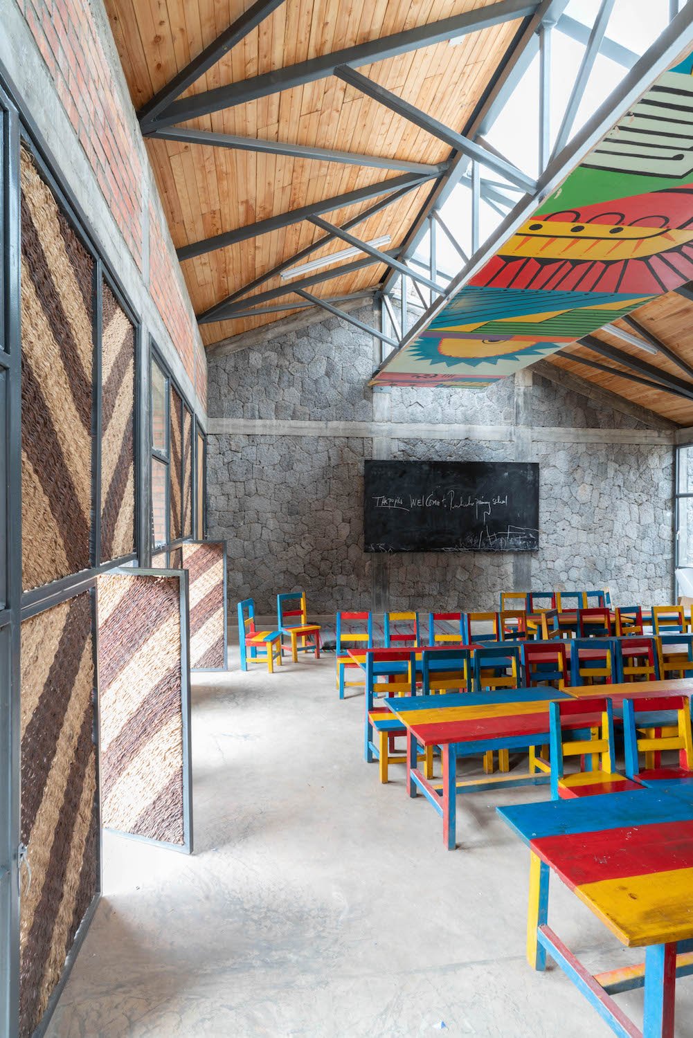 Vertical woven infill windows along the sides of the classrooms feature operable lower units, allowing for fresh air to enter the space. | MASS Design Group / Alan Ricks (Full Copyright)