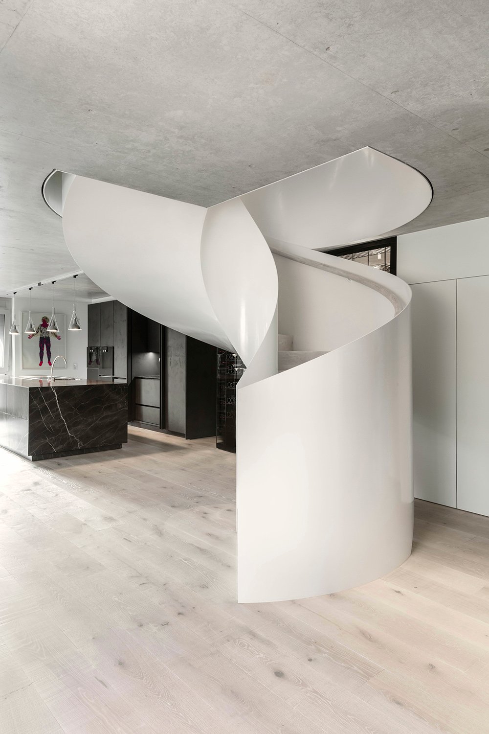 The white, monolithic-like spiral staircase vertically connects the three floors. | Delphine Burtin