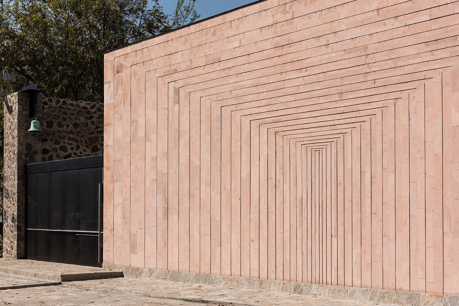 A pink stone wall was designed with a geometrical path that emphasize the patio's depth. | Jaime Navarro Soto