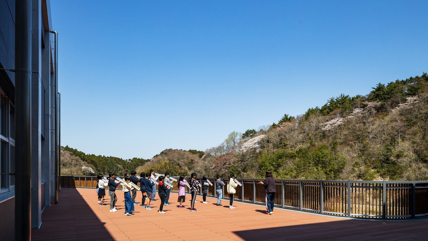 Students using large terrace for a music lesson amongst the natural scenery. | Kawasumi Kobayashi Kenji Photograph Office Co.,Ltd