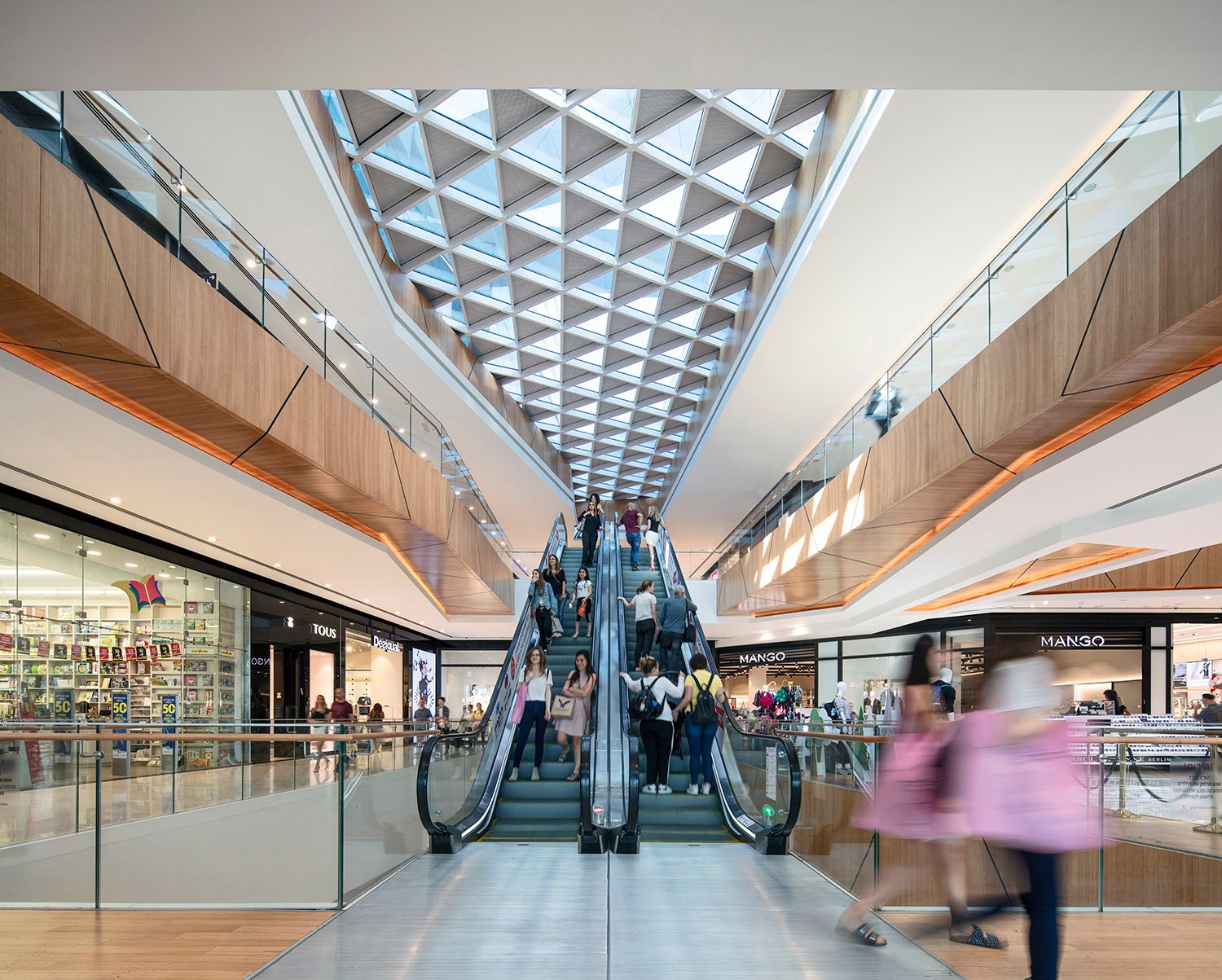 Azrieli Rishonim, the skylight and openings between the levels are "carved" out, defining seating areas, bridges connecting the public spaces, and changing views weaving the fluent space together. | Photo: Amit Geron