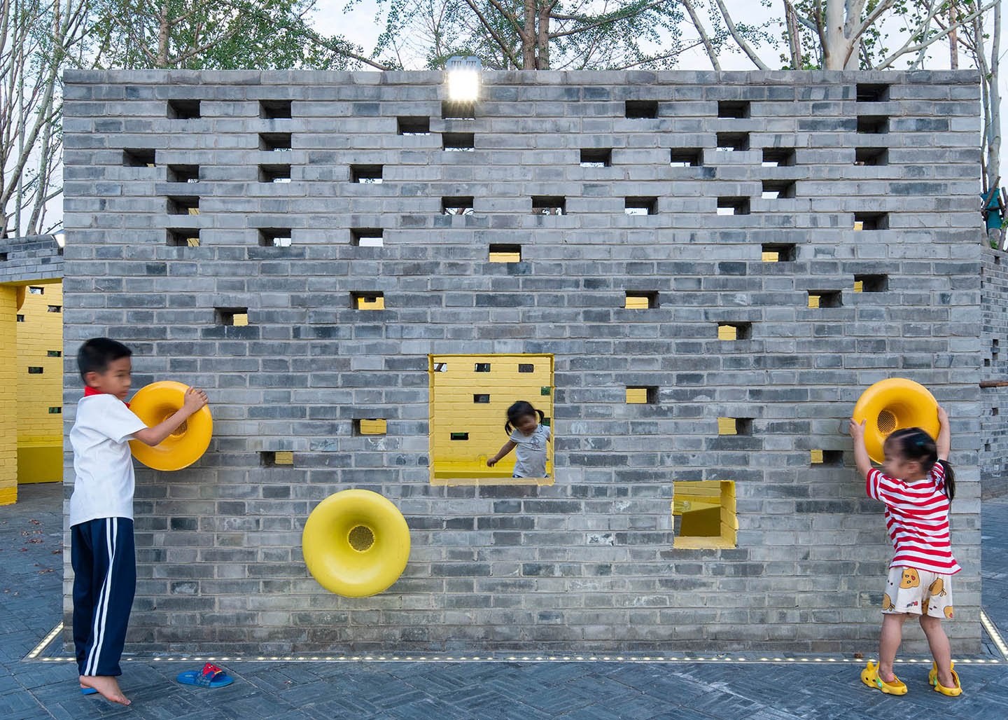 Play area, grey brick wall with speaking tubes | BAI Yu