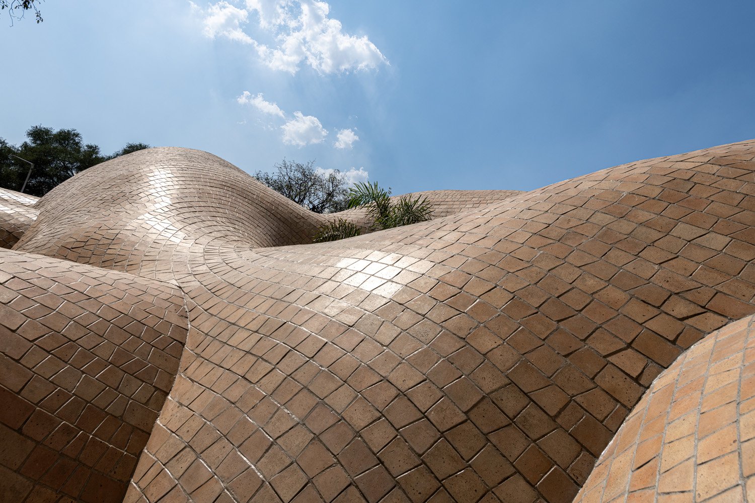 Gentle upswells. Soft swoops. Harmonic waves that birth an ambience of evocative silence, where the light speaks, the wind sings, and the earthenware roofing produces melody. | PHX India