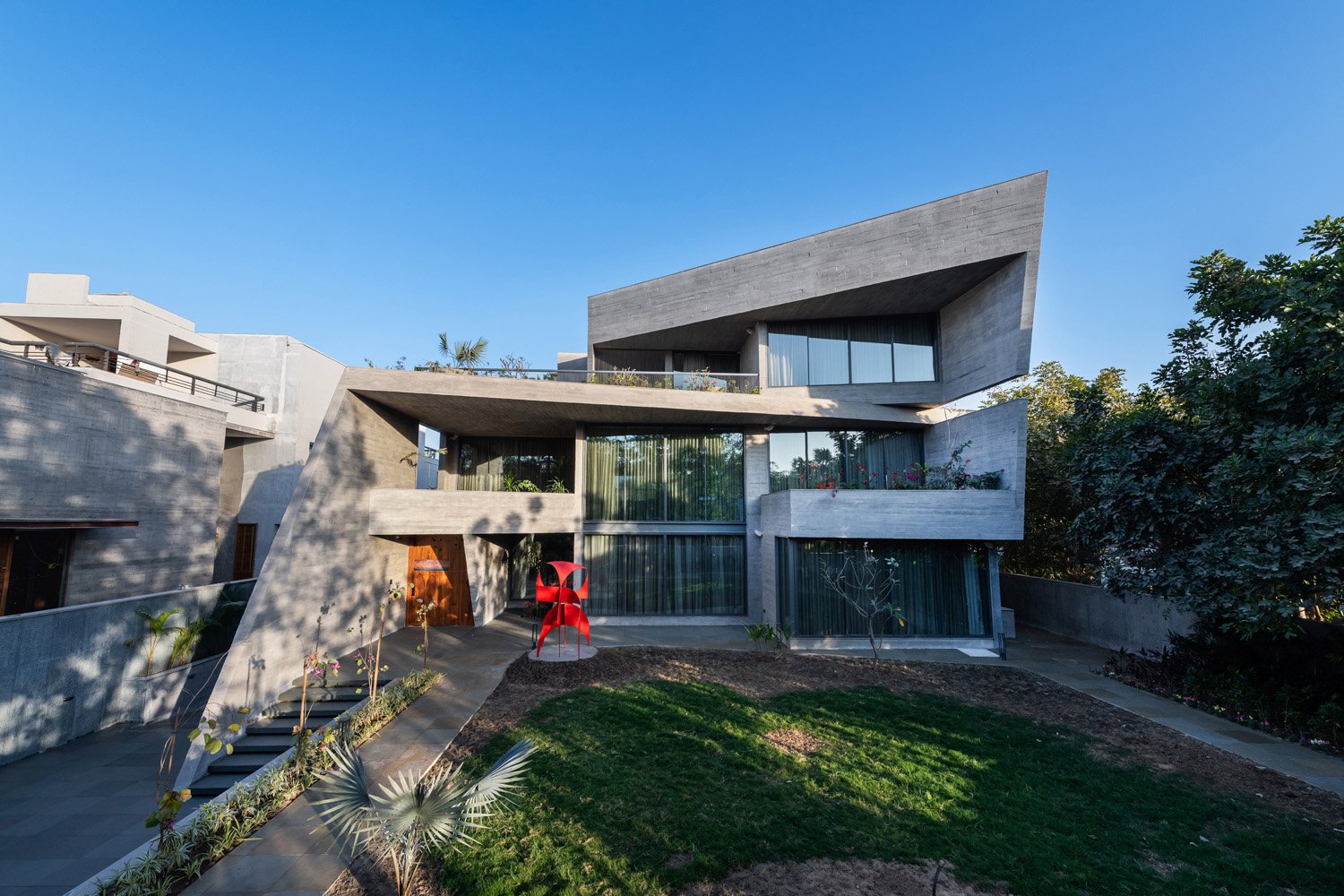 Controlling southwest sunlight was a challenge. Natural light's power to promote positivity and wellness is unmatched. Drought-friendly trees were strategically placed to shield the house from southwesterly heat as they grow. | PHX India