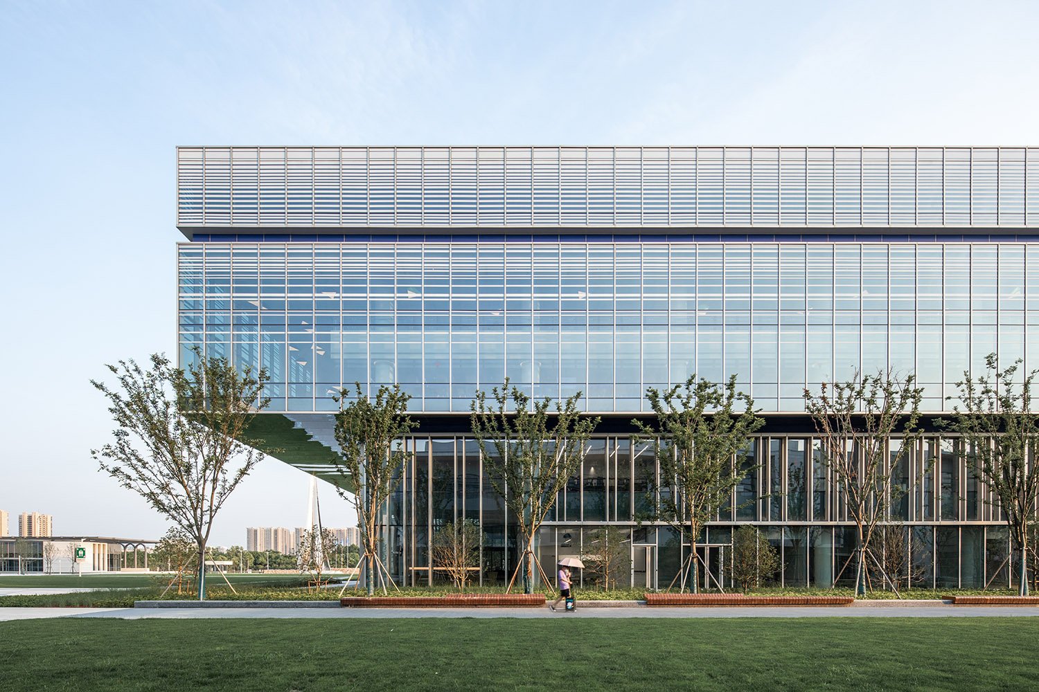 DKU's LEED-Gold certified library balances natural light and energy efficiency, using strategies like self-shading and vertical shading. A grand cantilevered structure creates a distinct entrance and an elevated reading room. | ©RAWVISION studio