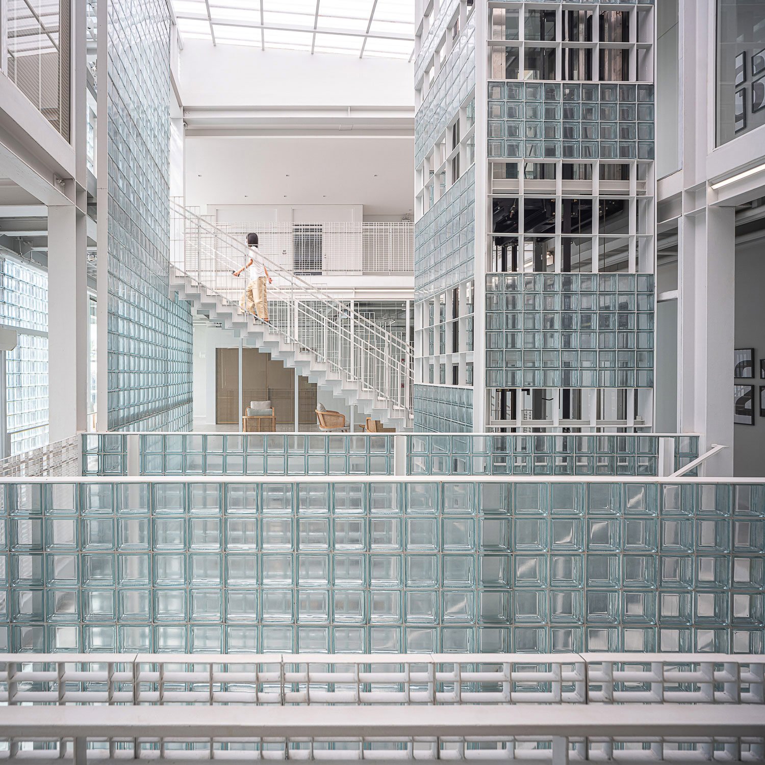 Central Atrium : An intricate array of glass blocks envelops this central atrium, playing with light and shadow to foster an open and bright environment, interconnected workspace. | © Spaceshift Studio