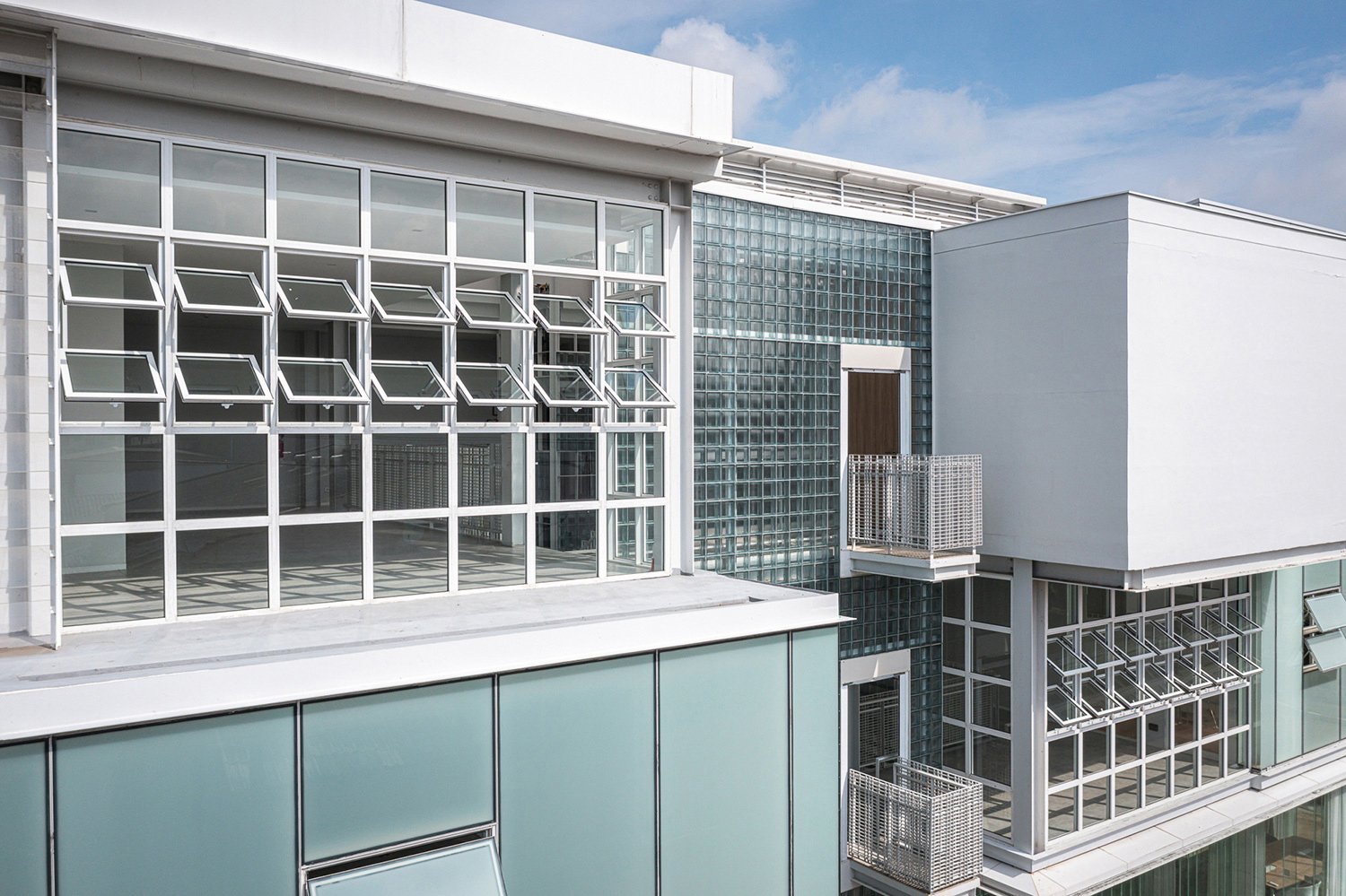 Building Exterior : Modern architectural facade featuring glass blocks and a fresh, clean aesthetic, integrates seamlessly into the urban environment. | © Spaceshift Studio