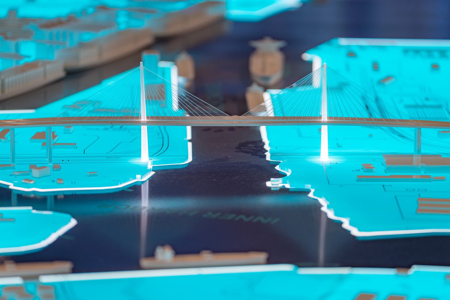 The large-scale illuminated 3D map table at the Port of Long Beach exhibition space offers a captivating and educational experience. Visitors can explore intricate details, such as the Long Beach International Gateway Bridge, gaining a tangible understand | Paul Vu