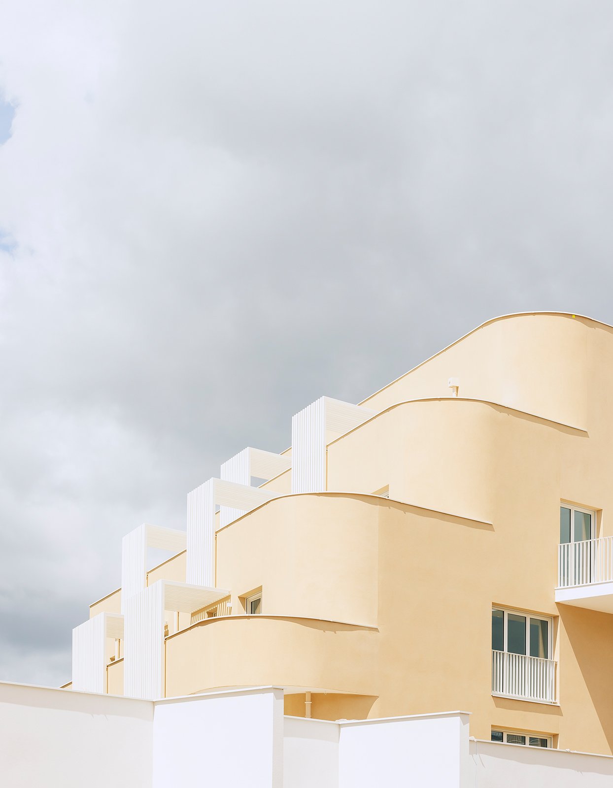The buildings with plaster facade, detail of the curved corner | ©Stefano Anzini