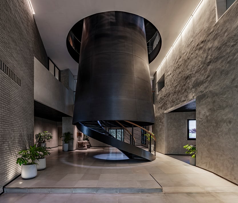 The independently accessible double level lobby and visitor interface areas are organized around a ‘skylit’ circular courtyard sheltered by the truncated cone that slices through the campus, echoing Bombay’s industrial past. | Bharath Ramamrutham