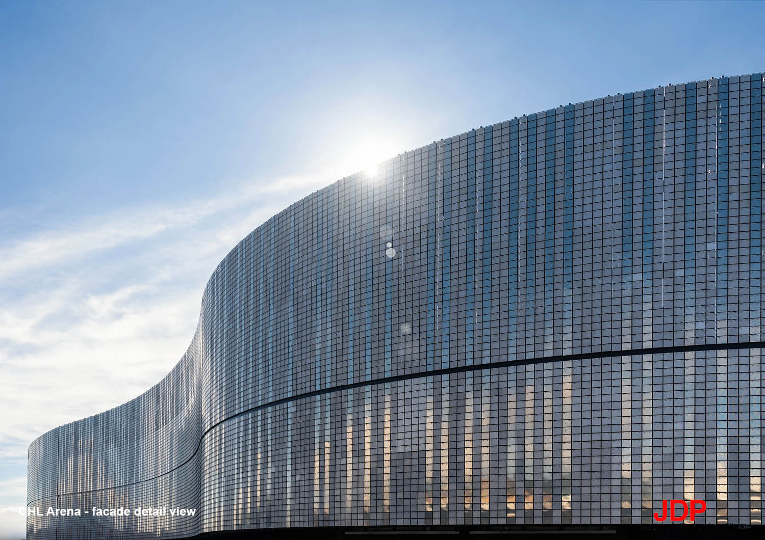 Facade detail with dynamic aluminium skin, composed of hinged and perforated silver tiles, alternating between glossy and matte finishes. | JDParchitects