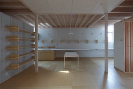 View towards the long counter with the kitchen to the left and the work space to the right | 