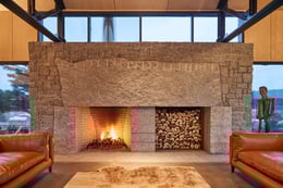 The 16' granite fireplace. The five-tonne live-edge mantle stone carries the marks of its making | Doublespace Photography Inc