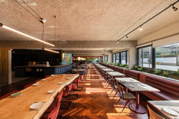 Anche lo spazio del bar-caffetteria e del ristorante sono stati aperti completamente spogliati di intonaci e partizioni e lasciati nel loro aspetto grezzo, con il pavimento in legno preesistente e lunghe p | Bruno Galizzi