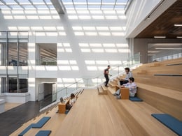 A broad skylight brightens the atrium, creating a welcoming atmosphere, while the upper-level stair expands into a stepped seating zone, encouraging visitors to pause, reflect, and interact socially. | ©RAWVISION studio