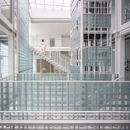 Central Atrium : An intricate array of glass blocks envelops this central atrium, playing with light and shadow to foster an open and bright environment, interconnected workspace. | © Spaceshift Studio