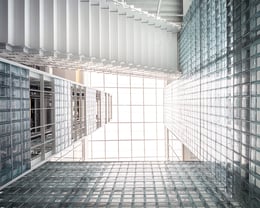 Triple Volume Space : A dramatic grand triple-height space encased in glass blocks, marrying architectural grandeur with functional, light-enhancing elements, enhancing the feeling of openness and integrating various building levels visually. | © Spaceshift Studio