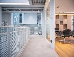 Working Room : A Sleek, modern office space setup adjacent to glass block features that offer privacy while maintaining a connection with the rest of the space, providing a tranquil and inspiring environment for creativity and productivity. | © Spaceshift Studio