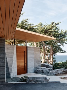 The entryway is nestled between angled stone walls that echo the cliff forms below. | Joe Fletcher