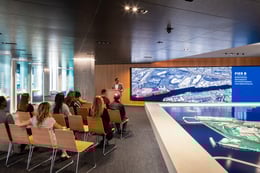 With the large scale interactive 3D map table and adjacent video wall, this multifunctional space can host a variety of activities and events, from special speaking events, like the one seen here, to collaborative educational experiences for the community | Paul Vu