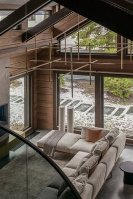 View of the living room from the second floor. This home has combined many functions. There are outdoor recreational areas, including an outdoor patio overlooking the courtyard. Chandelier, Flos. Floor lamps, Gubi | courtesy of LINES