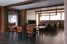 The open space of the kitchen-dining area. In the dining room there is a Bonaldo dining table, the base of which symbolizes an embrace. The table was complemented with Porro chairs, they are very light, with natural leather upholstery. The light fixture a | courtesy of LINES