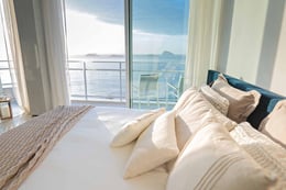 La Vue Penthouse - © Marcio Torrez, courtesy Luxivité International Property Group | La master suite, circondata da grandi vetrate, si presenta come un grande open space in cui la zona notte e l’area bagno si fondono in un unico ambiente. Dotata di una vasca freestanding, è completata da un grande blocco in marmo bianco con venature grigio scuro che ospita i lavabi.