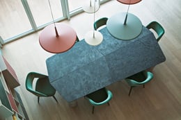 Casa S. | © Niccolò Morgan Gandolfi, courtesy Doodesign | Il tavolo da pranzo, completato da poltroncine  color salvia, è sovrastato da un lampadario composto da elementi circolari disposti a diverse altezze.