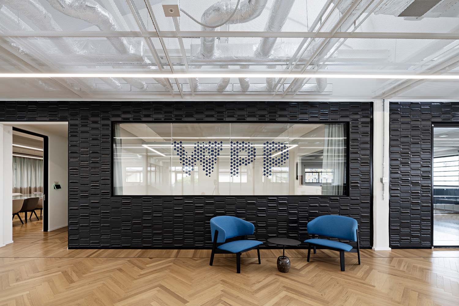 WPP Campus - © Andrea Martiradonna, courtesy 967ARCH L'interior design propone un'atmosfera industriale che alterna superfici monocromatiche e neutre con arredi colorati. Le pavimentazioni sono in parquet di rovere, resina e grès porcellanato.