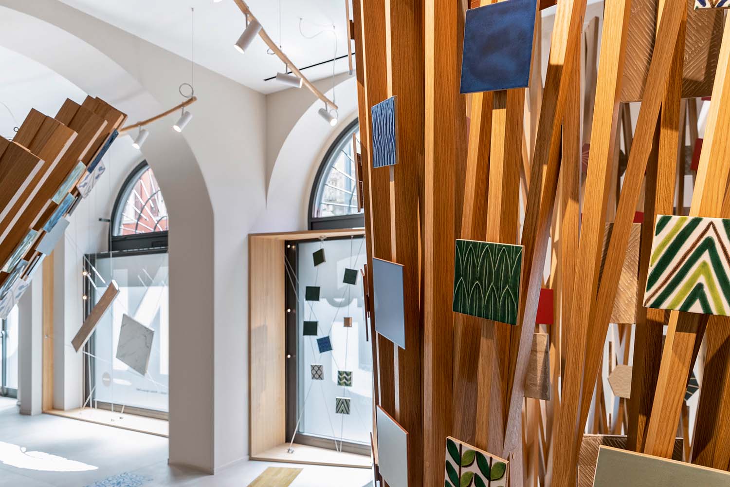 Flagship Showroom Ragno - © Tiziano Sartorio, courtesy Ragno (Marazzi Group) Le strutture in legno richiamano l’idea di una ragnatela: sono utilizzate per esporre le diverse collezioni dell’azienda, creando un caleidoscopio di colori.